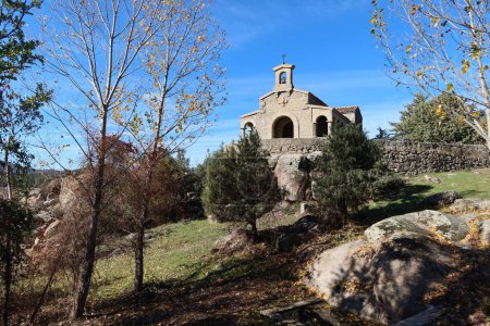 Foto de Embalse de El Burguillo, Ávila, España, 13 de noviembre de 2023: Pequeña ermita de El Carmen construida en piedra entre la vegetación del Embalse de El Burguillo, Ávila, España - Imagen libre de derechos