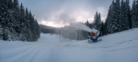 Téléchargez les photos : Canons à neige pulvérisation de neige dans les montagnes d'hiver.. Machine à neige. - en image libre de droit