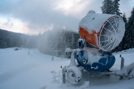 Téléchargez les photos : Canons à neige pulvérisation de neige dans les montagnes d'hiver.. Machine à neige. - en image libre de droit