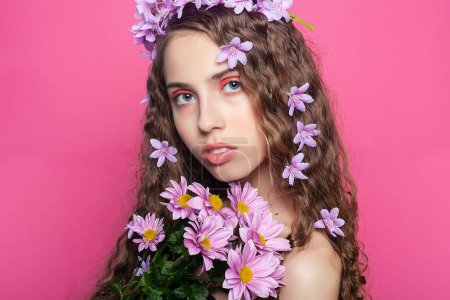 Foto de Intrincados rizos adornados con flores púrpuras enmarcan la cara de esta chica, añadiendo un toque encantador y romántico a su apariencia - Imagen libre de derechos