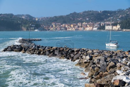 Foto de Muelle rocoso con vistas al golfo de los poetas con un velero a su lado. Lerici, Liguria, Italia - Imagen libre de derechos