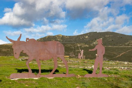 Photo for Mountains. Green mountains in the municipality of El Atazar, north of the Community of Madrid. Sunny day with air and clouds decorating the sky. Iron decoration on the green grass. Farmer. Donkey. - Royalty Free Image
