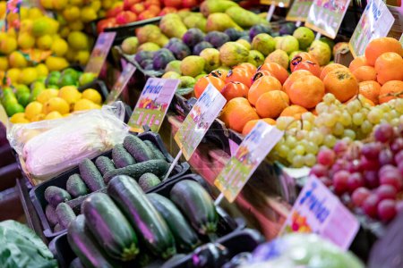 Foto de Fruits. Vegetables. Fruit and vegetable stall. Stall with lettuce, grapes, cucumbers, oranges and pears in a market in Madrid, Spain. Horizontal photography. - Imagen libre de derechos