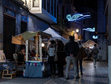 Photo for Felanitx, Spain; december 10 2022: Nighttime Christmas street market with people strolling. Felanitx, island of Mallorca, Spain - Royalty Free Image