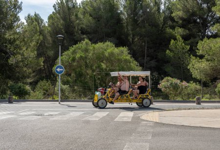Foto de Sa Coma, España; 03 de junio de 2023: Bicicleta tándem roja para 4 personas en el complejo turístico de Sa Coma, isla de Mallorca, España - Imagen libre de derechos