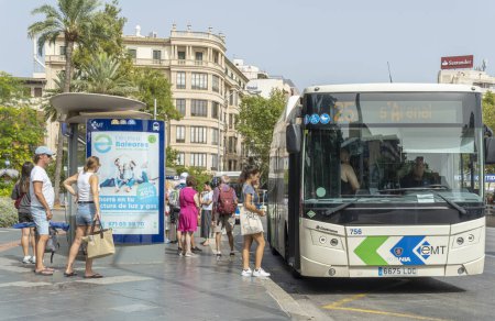 Foto de Palma de Mallorca, España; agosto 10 2023: Parada de autobús con pasajeros y autobús de la empresa pública EMT, Palma de Mallorca, España - Imagen libre de derechos