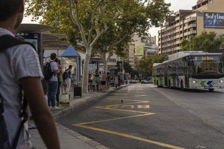 Foto de Palma de Mallorca, España; 11 de septiembre de 2023: Parada de autobús con pasajeros esperando el autobús de la empresa pública EMT, Palma de Mallorca, España - Imagen libre de derechos