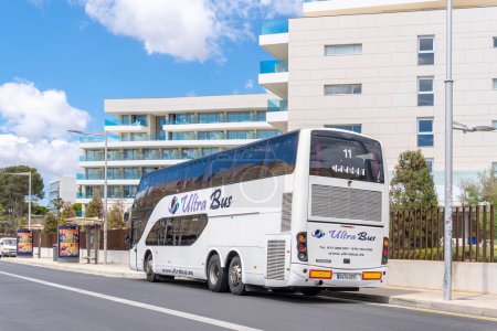 Foto de Palma de Mallorca, España; 08 may 2024: Autobús turístico Ultra Bus estacionado frente a un moderno hotel de lujo en el complejo turístico de Playa de Palma, Mallorca - Imagen libre de derechos