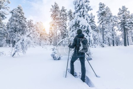 Téléchargez les photos : Randonneur en raquettes marchant dans la neige. Activité sportive d'hiver en plein air et mode de vie sain concept. - en image libre de droit