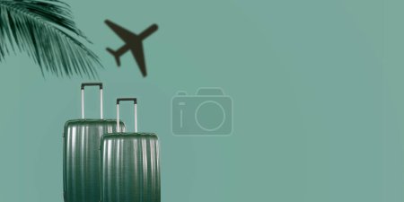 Téléchargez les photos : Sacs de voyage de luxe vert avec ombre d'avion et feuille de palmier sur fond vert. Espace de copie. - en image libre de droit