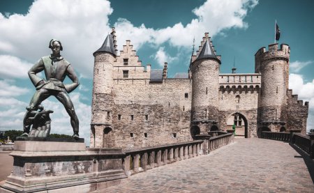 Foto de Amberes, Bélgica - 10 de julio de 2023: Estatua de Lange Wapper frente al castillo medieval Het Steen en el centro histórico de Amberes. - Imagen libre de derechos