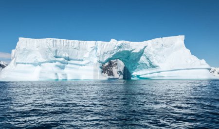 Massive tabular iceberg with arch shape. Booth Island, Antarctica.