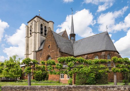 Gotische Sankt-Martin-Kirche umgeben von Spalieren in Wezemaal, Rotselaar, Belgien.