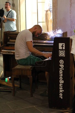 Photo for Ferrara, Italia - August 26, 2022: The Ferrara Buskers Festival is dedicated to the art of the street. A solo piano is not enough to create complex melodies, artist Piano Busker. - Royalty Free Image