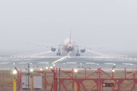 Verkehrsflugzeuge landen im Nebel. Flugzeug-Räder berühren bei nebliger Landung die Landebahn.
