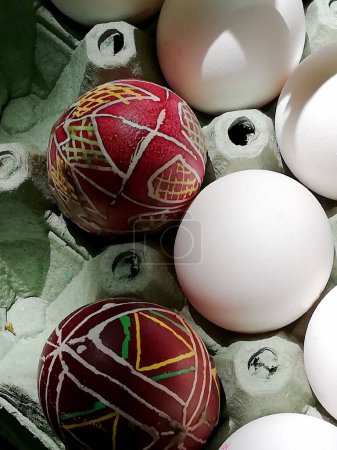 bemalte Ostereier im ukrainischen Stil und ein weißes Ei in einem Tablett