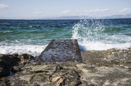 Sommerlandschaft eines schönen blauen Meeres mit einer steinernen Brücke. Insel Ägina, Griechenland