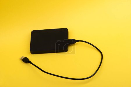 Foto de Unidades de disco duro portátiles externas negras aisladas sobre fondo amarillo - Imagen libre de derechos