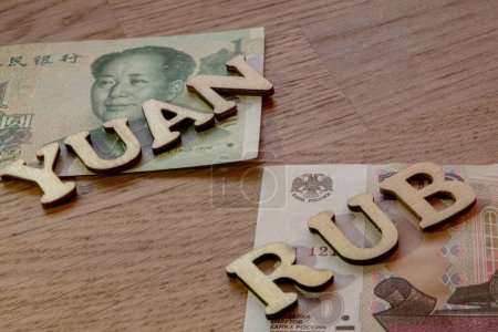 Téléchargez les photos : Devise yuan chinois et rouble russe frotter thème de taux de change croisé, yuan et mot frotter concept fait de lettres en bois sur fond en bois - en image libre de droit