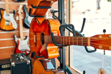Foto de Primer plano de una cuerda de guitarra en una tienda de instrumentos musicales. Muchas guitarras diferentes a la venta. Aficiones y recreación. - Imagen libre de derechos