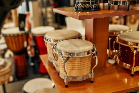 Foto de Comprar tambores en una tienda de instrumentos musicales. Muchos tambores diferentes en los estantes de la tienda para la venta. Aficiones y recreación. - Imagen libre de derechos
