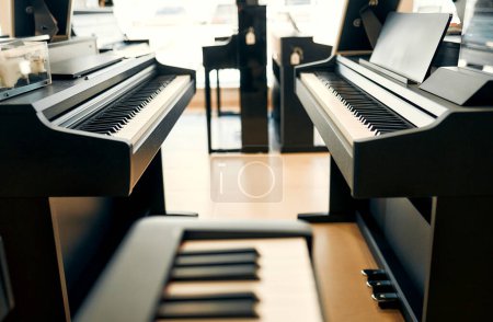Foto de Close-up of black piano keys in a musical instrument store. Lots of different keyboard instruments for sale. Hobbies and recreation. - Imagen libre de derechos