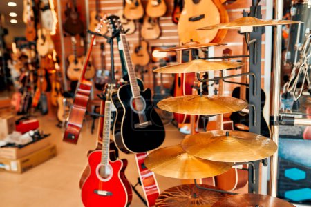 Foto de Comprar un kit de guitarra y batería en una tienda de instrumentos musicales. El interior de una tienda de instrumentos musicales. Aficiones y recreación. - Imagen libre de derechos