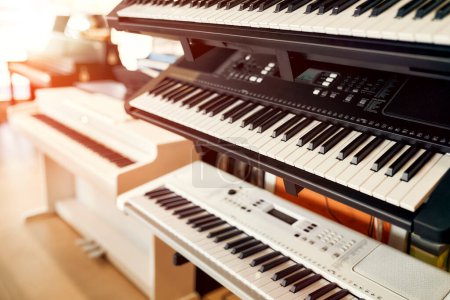 Foto de Primer plano de sintetizadores y teclados midi en una tienda de instrumentos musicales. Muchos instrumentos de teclado diferentes para la venta. Aficiones y recreación. - Imagen libre de derechos