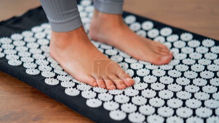 Photo for Cropped image of women's feet standing on a needle massager applicator. - Royalty Free Image