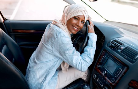 Photo for Young muslim woman in hijab sitting behind the wheel of a car. Buying and renting a car. Travel and recreation. - Royalty Free Image
