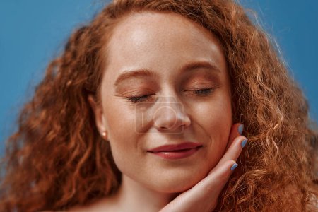 Photo for Redhead with freckles young plump plus size woman in white lingerie isolated on blue background. Body positive, skin care and cosmetology. - Royalty Free Image