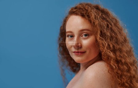 Photo for Redhead with freckles young plump plus size woman in white lingerie isolated on blue background. Body positive, skin care and cosmetology. - Royalty Free Image