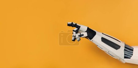 Téléchargez les photos : Robot main montrant le doigt sur l'espace vide sur le fond pour l'insertion isolé sur fond orange. Collaboration entre les humains et l'intelligence artificielle. - en image libre de droit