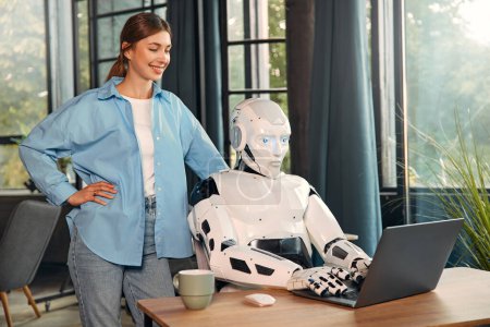 Photo for Young woman with a cup of coffee and a humanoid robot working while sitting at a laptop in a modern office. Collaboration between humans and artificial intelligence. - Royalty Free Image