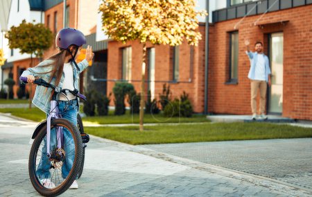 Foto de Un padre feliz le enseñó a su hija a andar en bicicleta. Un niño aprende a andar en bicicleta. Actividades familiares en verano. - Imagen libre de derechos