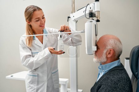 Foto de Examen ocular de un hombre maduro con oftalmología diagnóstica en una clínica óptica. Examen oftalmológico profesional de la visión del paciente. Máquina de horopter, chequeo de salud ocular. - Imagen libre de derechos