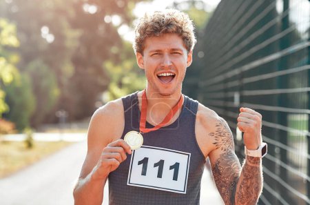 Photo for Male winner in sportswear with number showing gold medal for first place and celebrating. Sports and Olympic Games, victory concept. - Royalty Free Image
