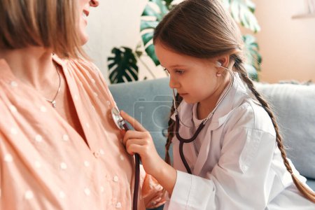 Photo for Child examining grandmother by kids stethoscope. Medicine and health care. Family visit. Generations love and relationship concept. - Royalty Free Image