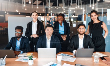 Photo for Team of successful young business workers in formal suits with laptops in modern office. Young people of different nationalities working in a coworking space. - Royalty Free Image