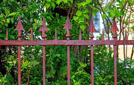 rusty red spear heads at a garden fence of a villa in the spa community of Bath Voeslau in Lower Austria, Austria