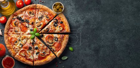 Téléchargez les photos : Savoureux pepperoni pizza et ingrédients de cuisine tomates basilic sur fond de béton noir. Vue du dessus de pizza au pepperoni chaud. - en image libre de droit