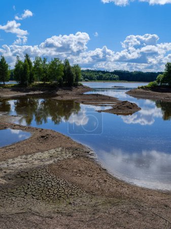 Téléchargez les photos : Lit de rivière drainé sans eau est l'été avec des reflets de nuages - en image libre de droit