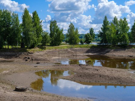 Téléchargez les photos : Lit de rivière drainé sans eau est l'été avec des reflets de nuages - en image libre de droit