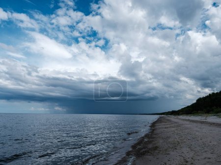 Téléchargez les photos : Nuages de pluie blanche sur la campagne en été avec ciel bleu et contraste élevé - en image libre de droit