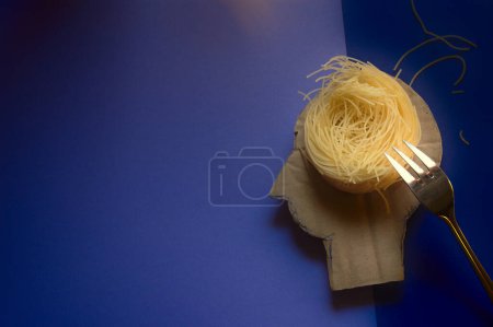 Photo for Human head with a nest of spaghetti thoughts and a silver fork. The concept of mental health, exhaustion, chaotic thoughts, human psychology and the study of the human brain. - Royalty Free Image