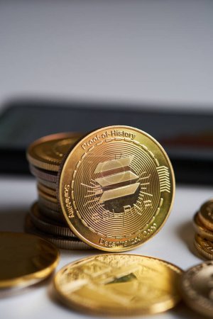 Golden Solana cryptocurrency surrounded by various cryptocurrencies and smartphone