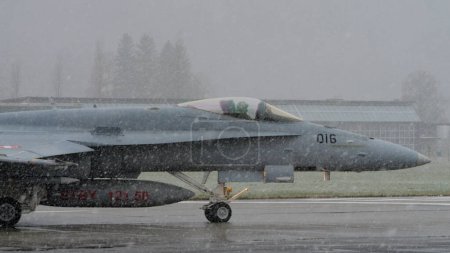 Photo for Meiringen Air Base Switzerland JANUARY, 18, 2013 Military pilot in the cockpit ready to take off in the snow with low visibility. McDonnell Douglas F-18 Hornet of Swiss Air Force. Copy space. Modern - Royalty Free Image