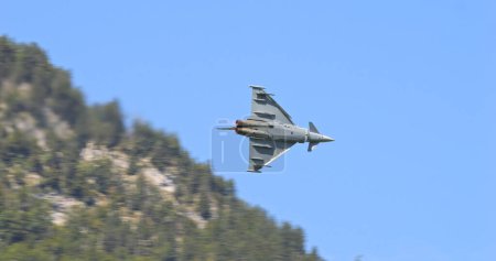 Photo for Mollis, Switzerland, August 19, 2023: Fighter jet with afterburners against a mountainous backdrop. Eurofighter Typhoon of German Air Force - Royalty Free Image