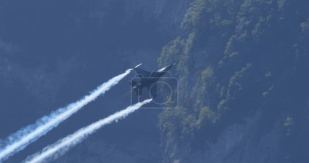 Foto de Mollis Suiza 19 de agosto de 2023: Aviones de combate se elevan a alta velocidad a baja altitud sobre el bosque verde. Copiar espacio. General Dynamics F-16 Fighting Falcon of Belgian Air Force Viper Demo - Imagen libre de derechos