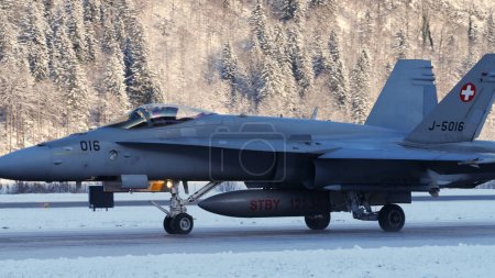 Photo for Meiringen Switzerland January 19 2023: Fighter jet taxiing in white winter snow scenario. Copy Space. Boeing F-18 Hornet of Swiss Air Force air defense for World Economic Forum WEF in Davos. - Royalty Free Image